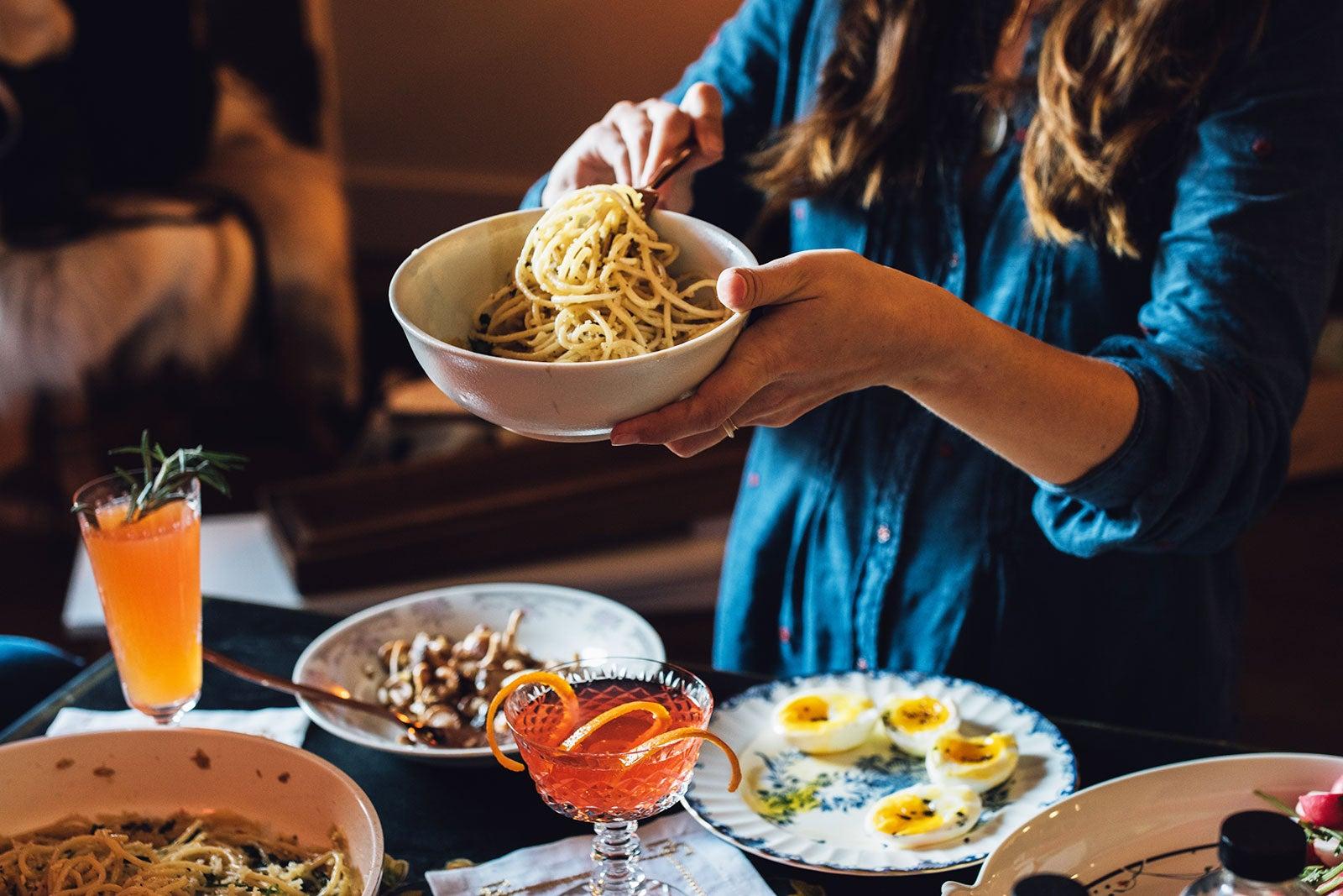 A woman dishing up pasta.