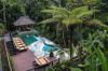 An infinity pool with its deck and gazebo set within a jungle viewed from above at Hanging Gardens of Bali.