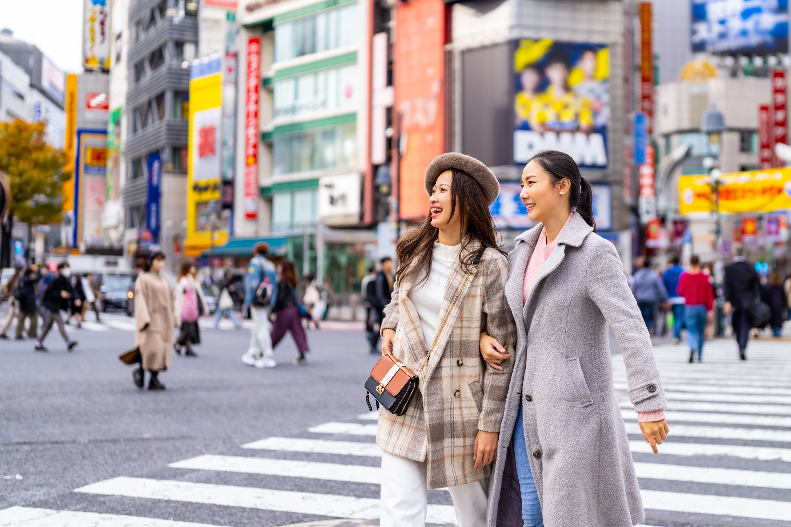 Two women cross a busy street in Korea.