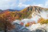 Mountain with fall colors and steaming pool.
