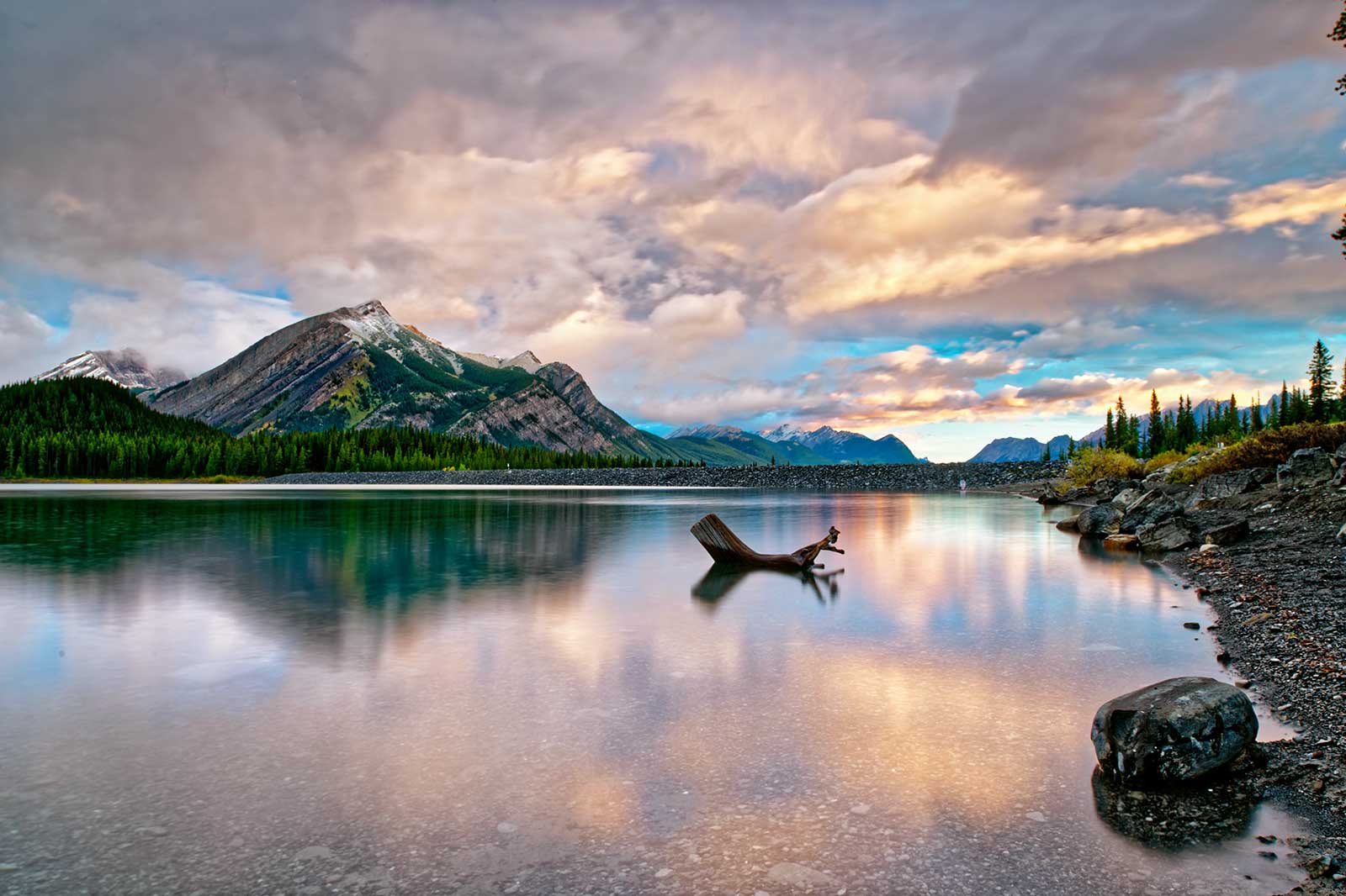 A lake, rocks, mountains in the background.
