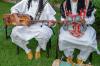 Gnawa musicians playing traditional instruments in colorful robes during a Moroccan performance.