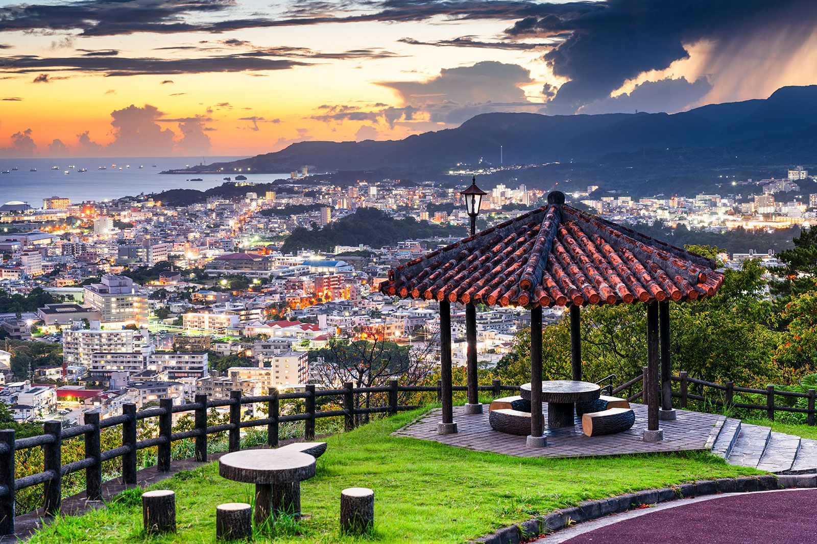 Tables and benches with a view of a city and bay.