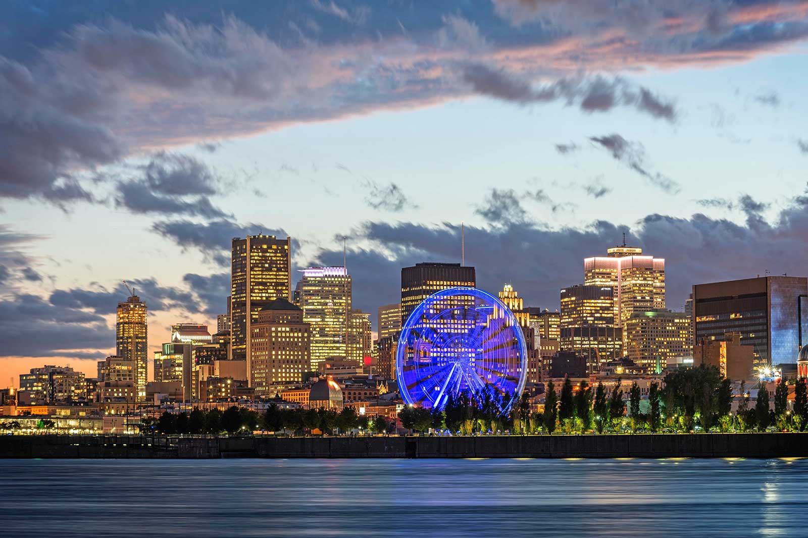 Dark clouds over a city with a Ferris wheel.