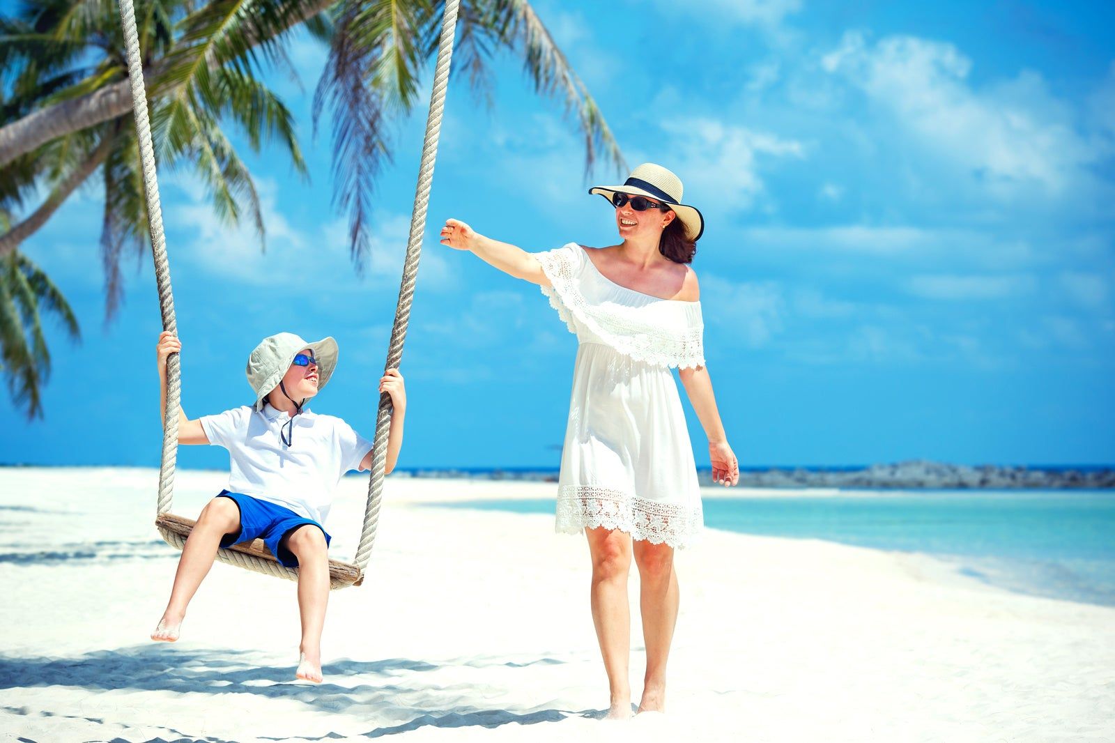 A parent and a kid on beach.