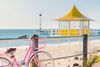 Pink bike and yellow tower at Brighton Beach.
