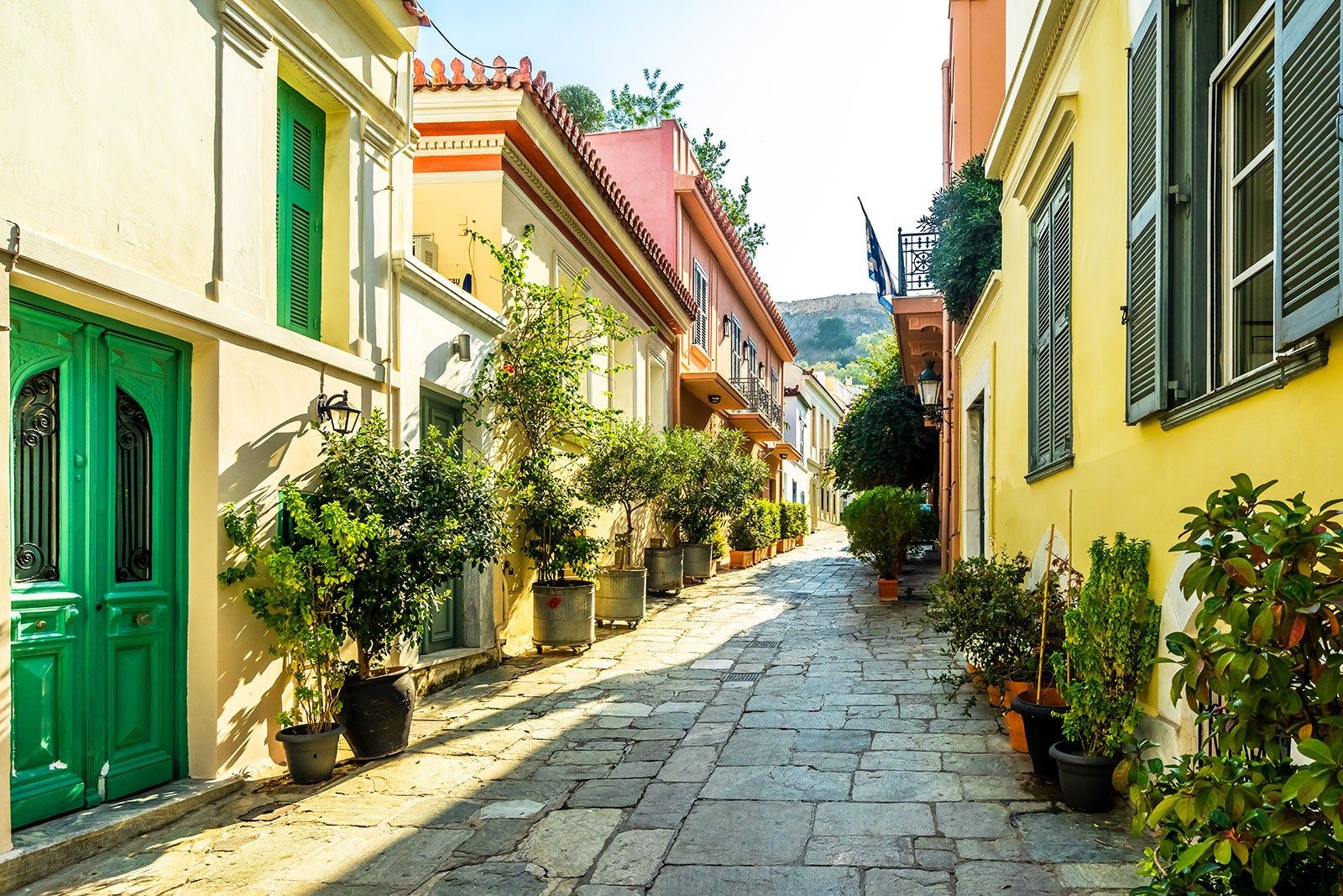 A narrow alley lined with colourful houses and potted plants.
