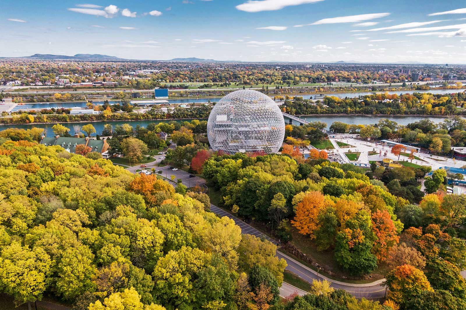 The view of the city in autumnal colors and large sphere shaped building in the center.