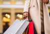 A woman wearing a coat carrying shopping bags.