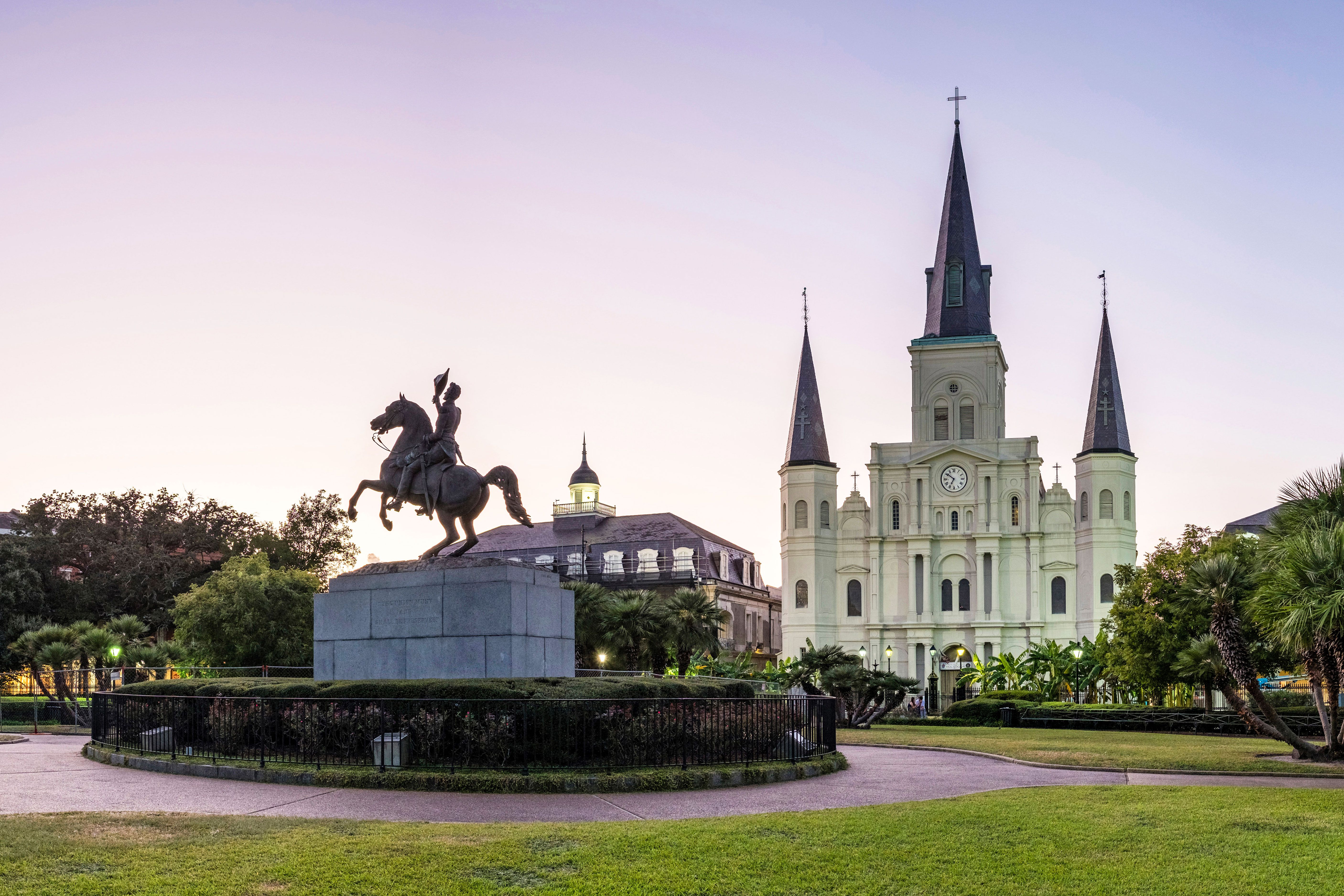 A statue of a military figure on horse with prominent building in background.