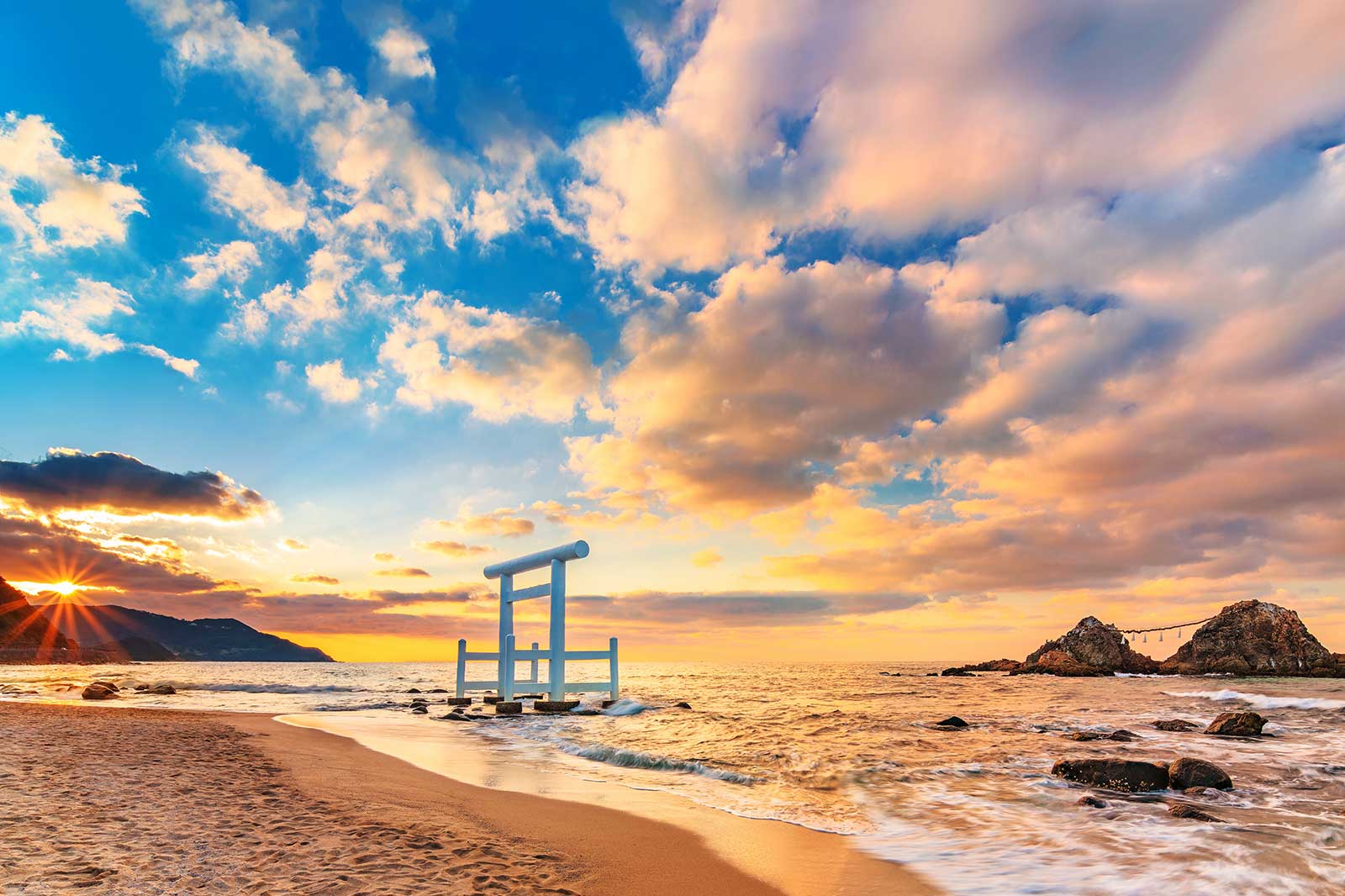 A Japanese shrine gate on a beach.