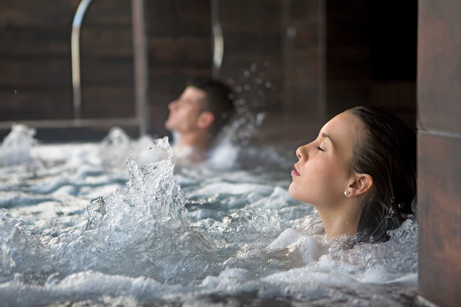 A couple sitting in a jacuzzi.