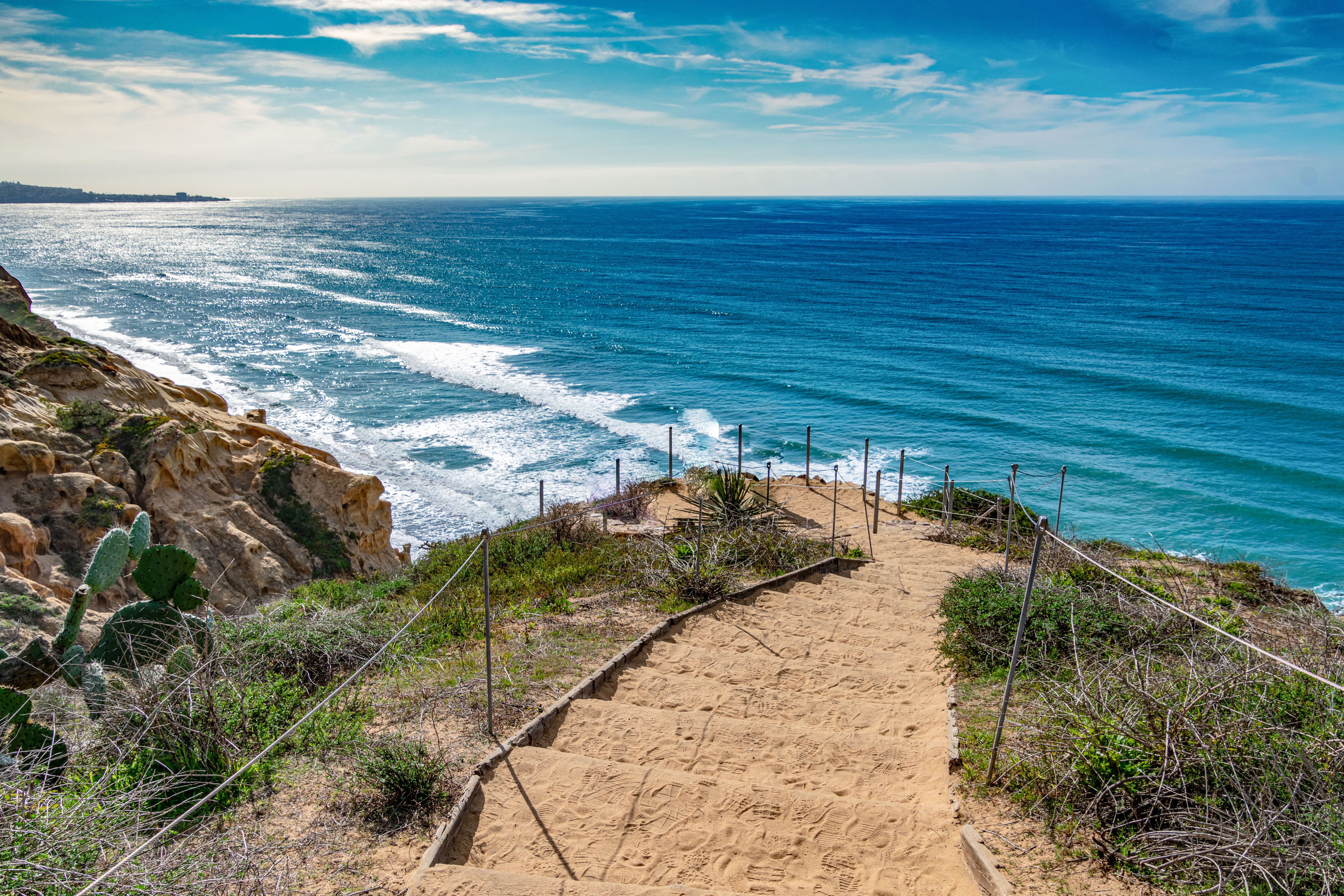 Sand covered steps lead down to the surf of San Diego.