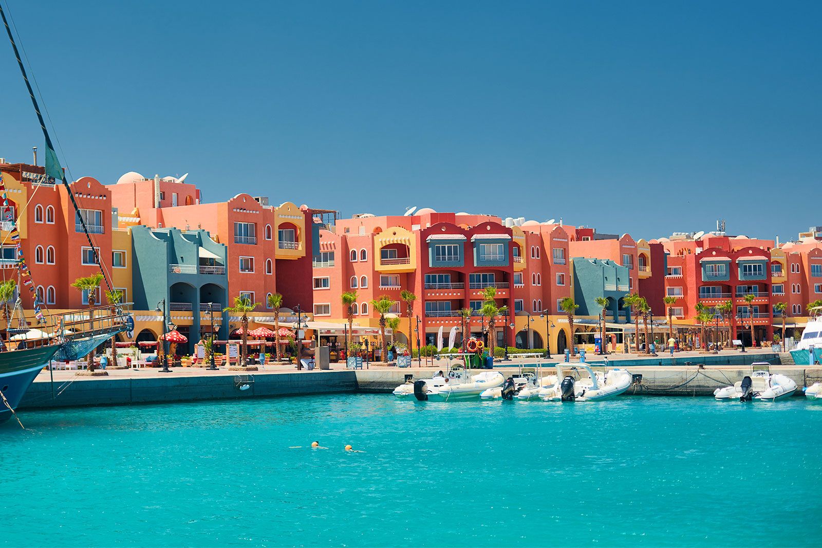 A panoramic seascape on colorful Marina promenade street with yachts in the harbor.