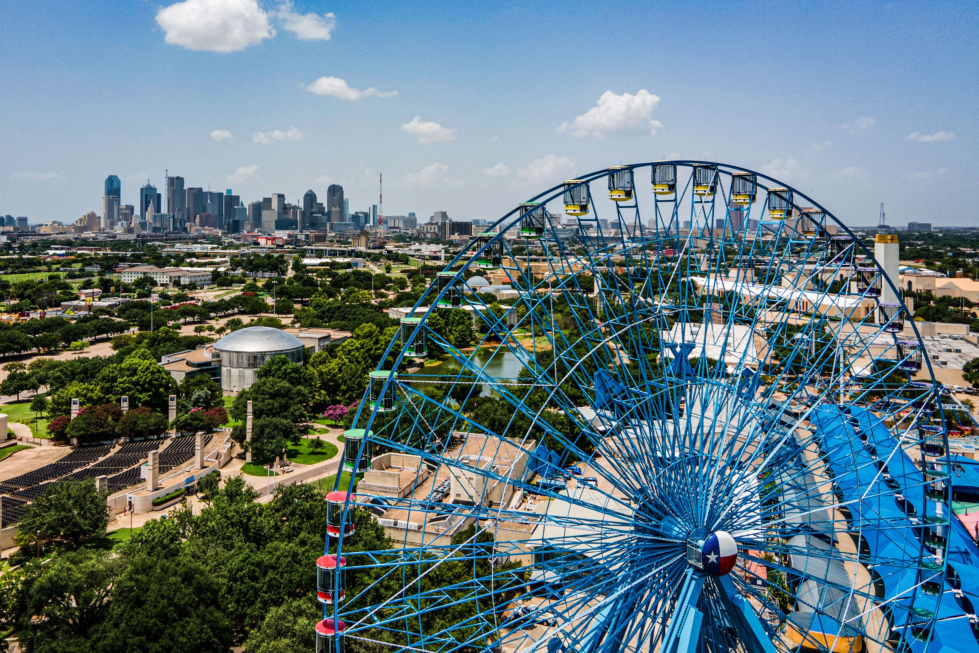 A big Ferris Wheel with a view of Dallas in the background.