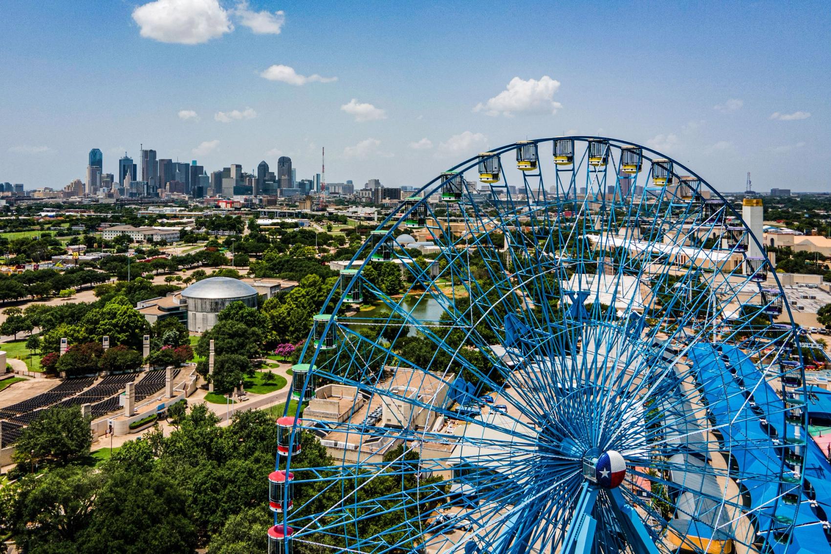 A big Ferris Wheel with a view of Dallas in the background.