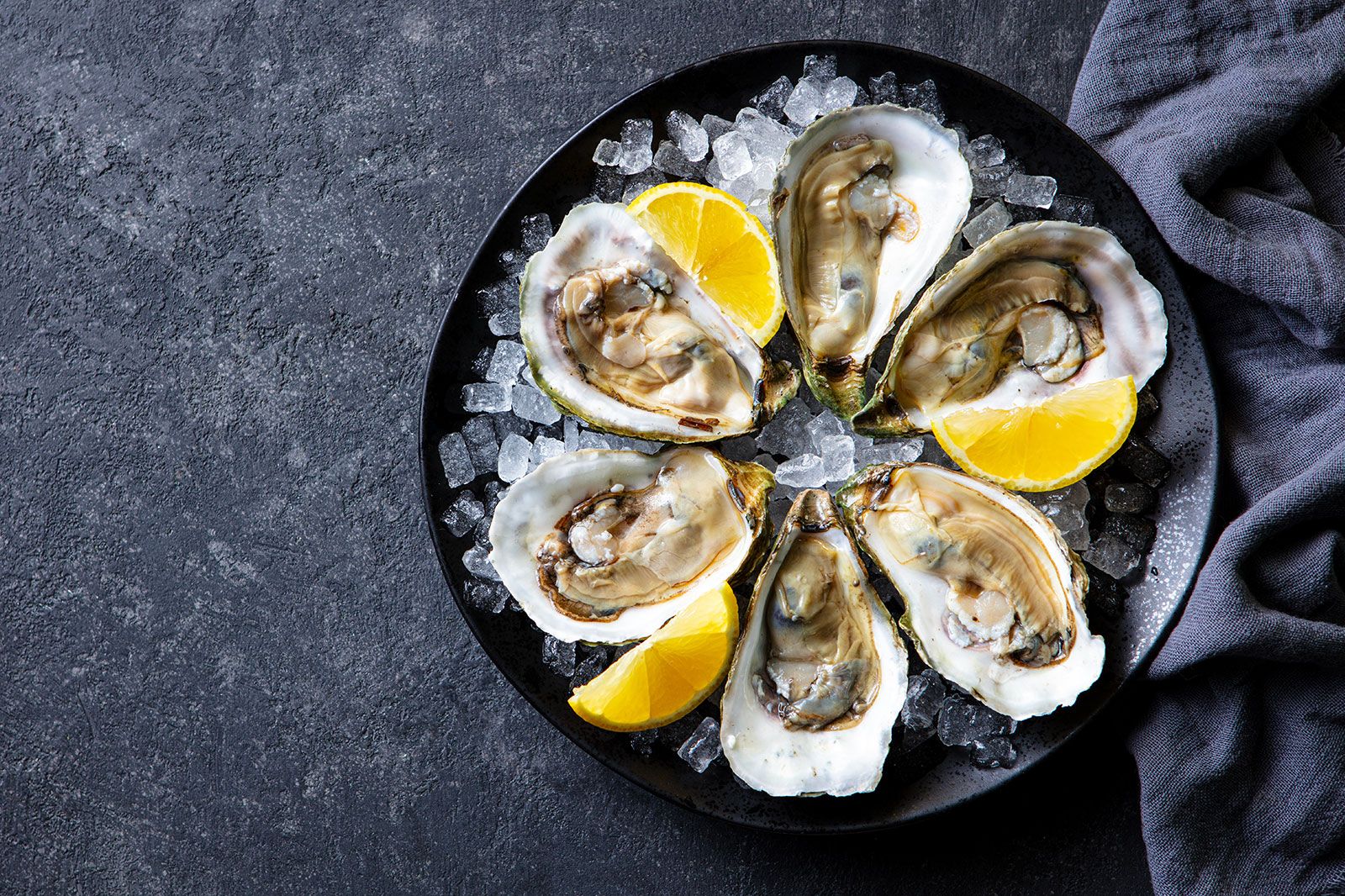 Fresh oysters with lemon on crushed ice.