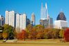 A view of a city skyline above fall colored trees.