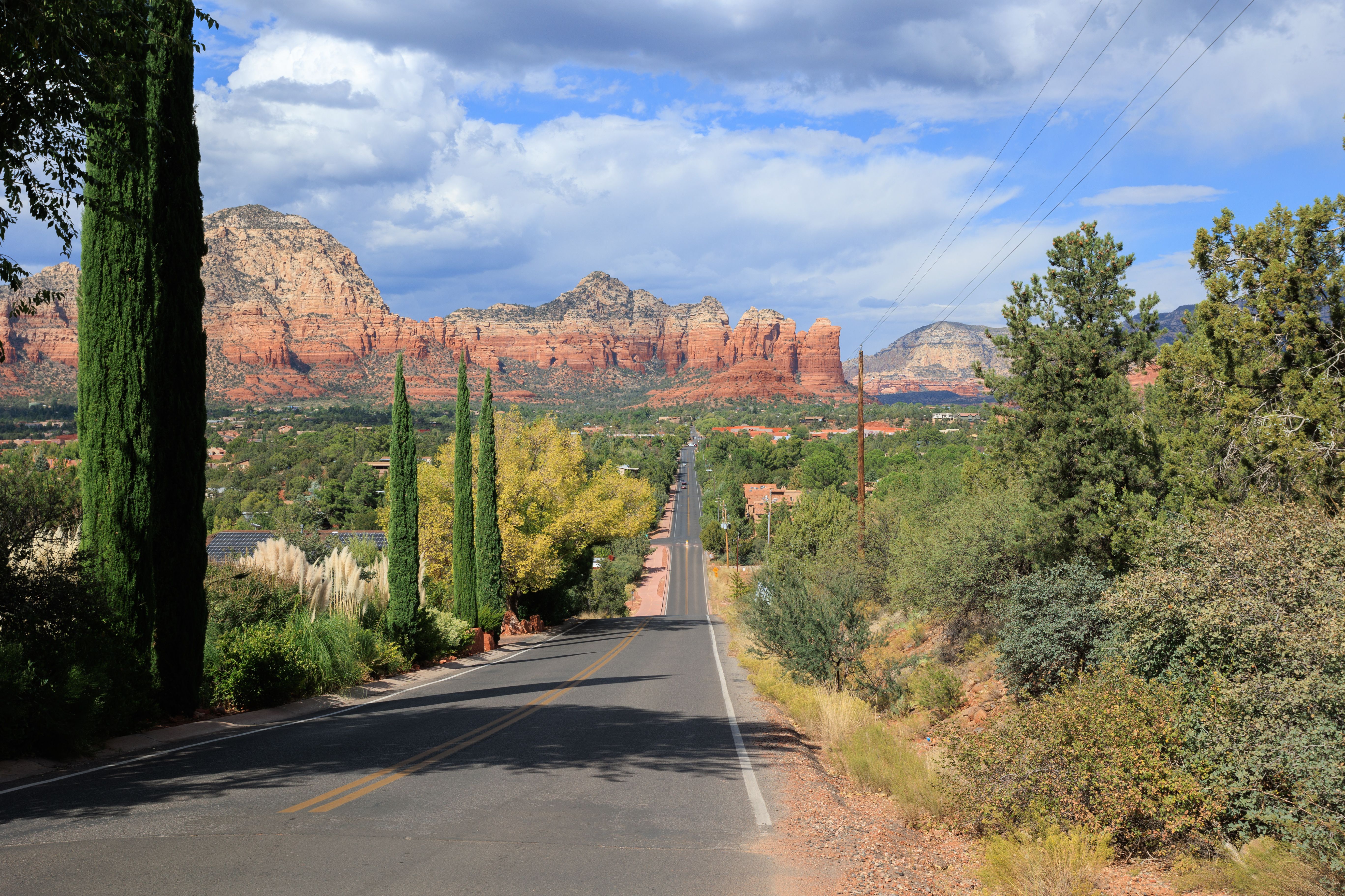 A long road leading to huge red cliffs in the distance.