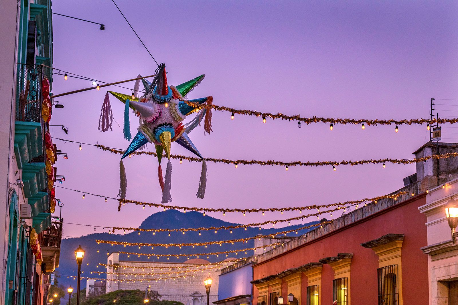 A colorful Mexican pinata and lights in a street. 