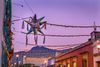 A colorful Mexican pinata and lights in a street.