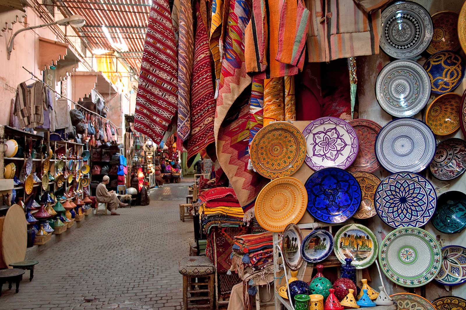 Dishes and rugs on display on a Moroccan souk.