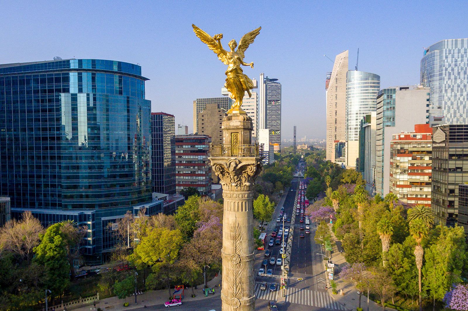 A statue of an angel in the middle of a city.