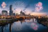 A view from the river of the Nashville city skyline at dusk with fireworks.