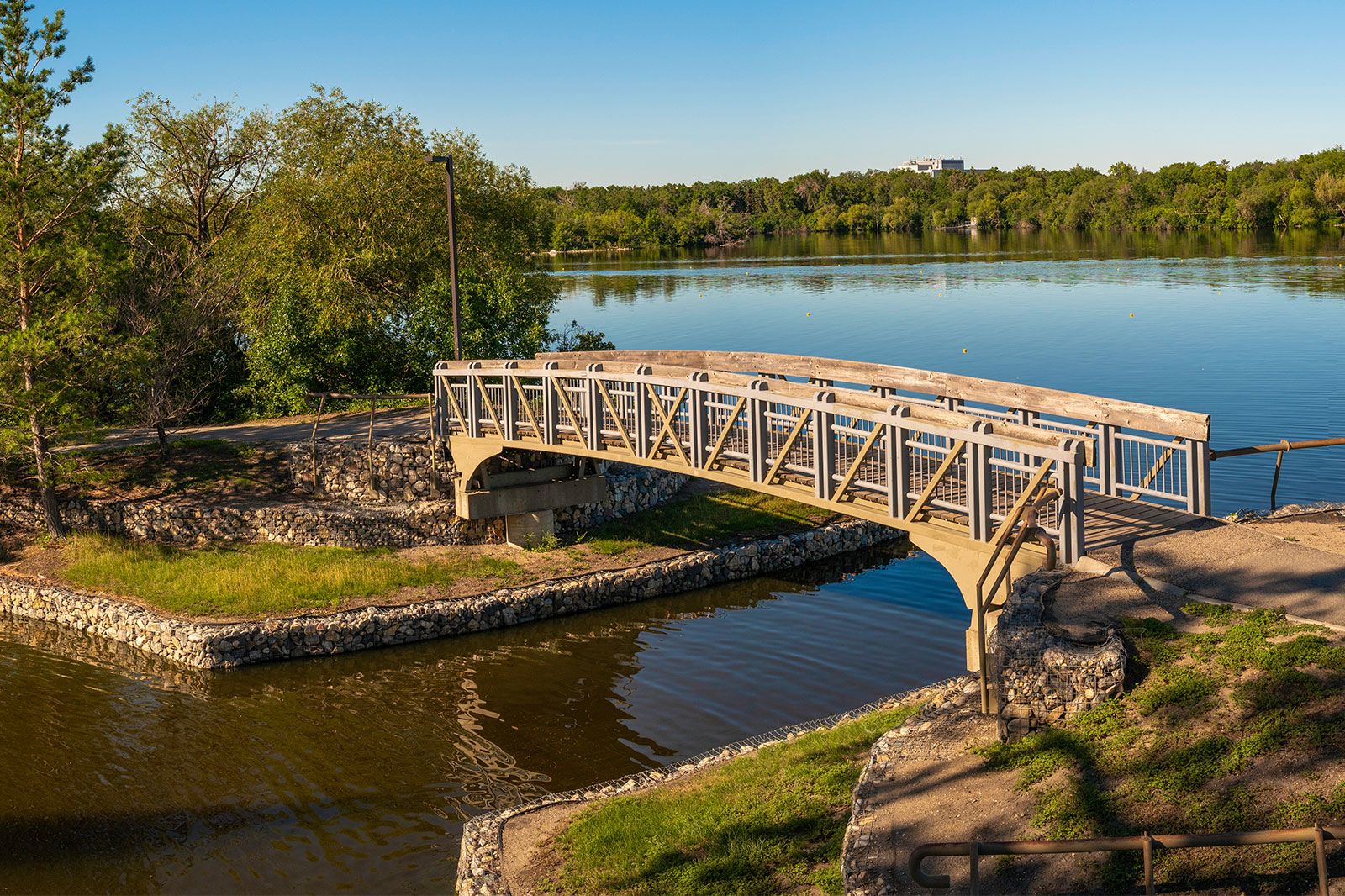A lake and bridge along a walking trail of a lake park.