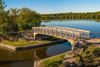 A lake and bridge along a walking trail of a lake park.