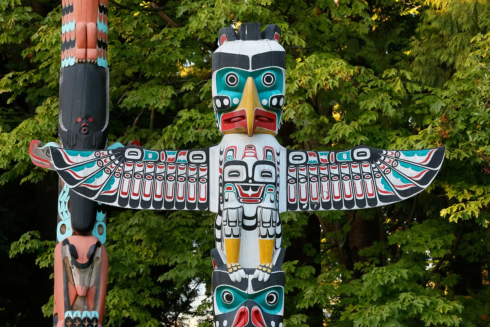 A large bird carving on a totem pole.
