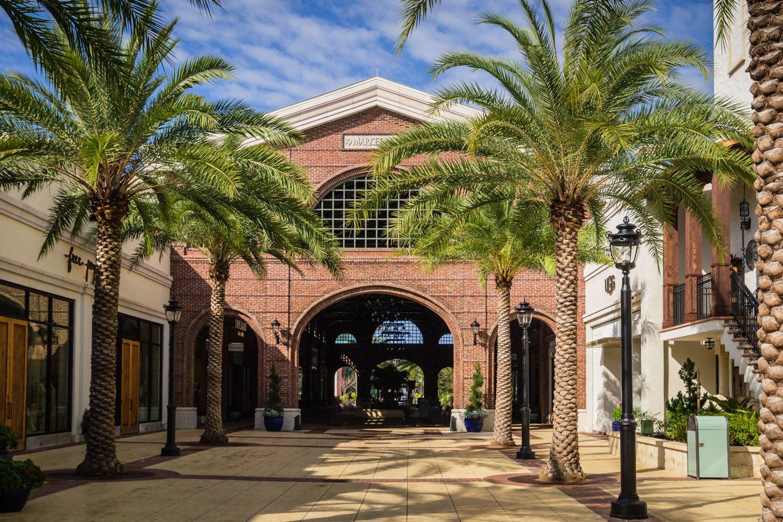 Red brick building with palm trees.