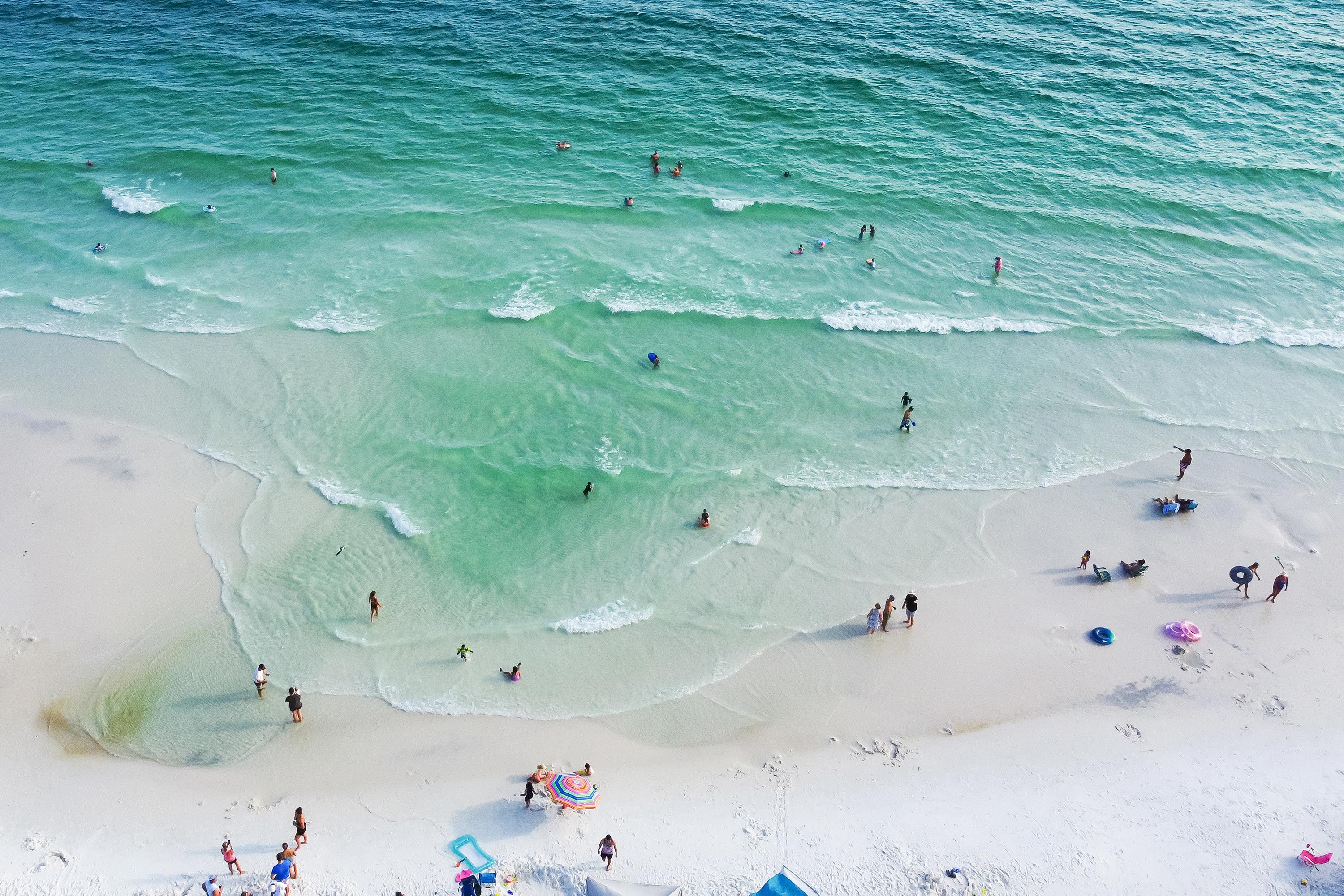 Aerial view of people in the turquoise water and on the white sandy beach on the Gulf Islands National Seashore in Florida.