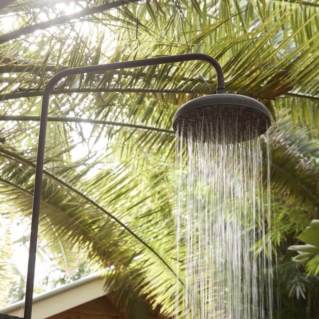 Get close to nature in the outdoor shower, pictured with large ferns arching overhead