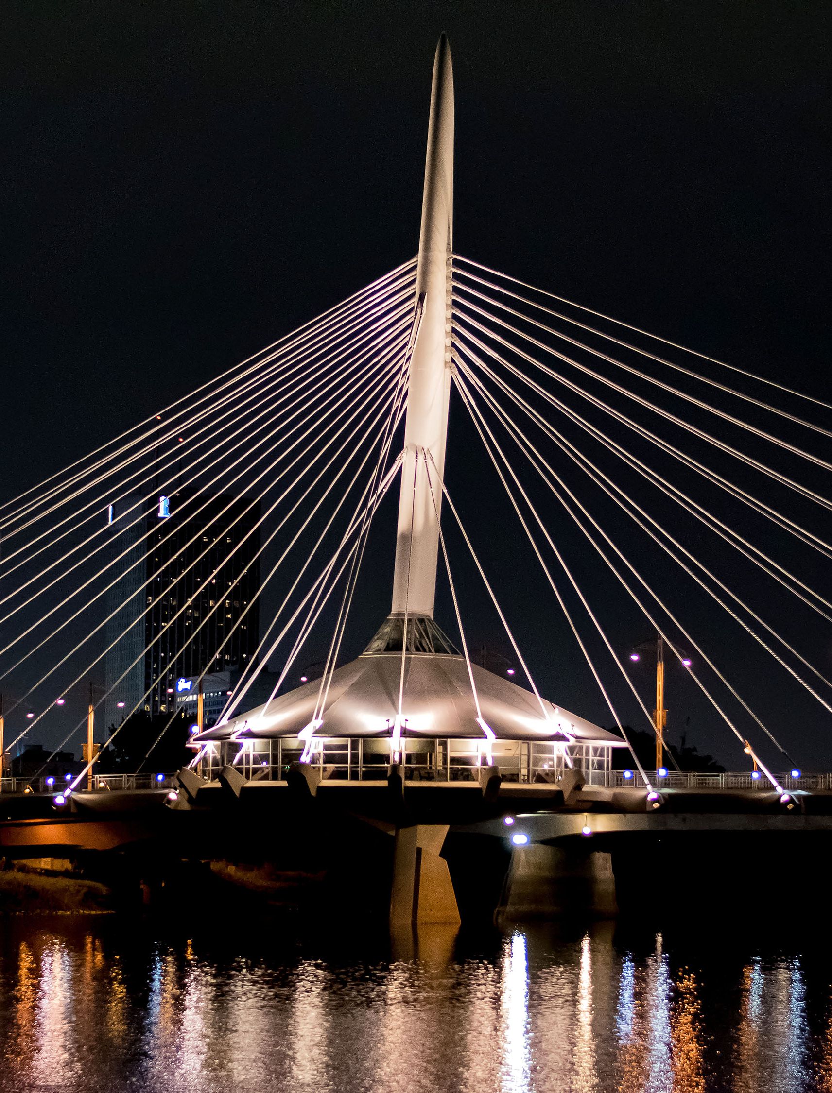 Night view of a lit-up modern suspension bridge.