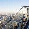 A person rides up the glass-sided Shibuya Sky Escalator in Tokyo, Japan