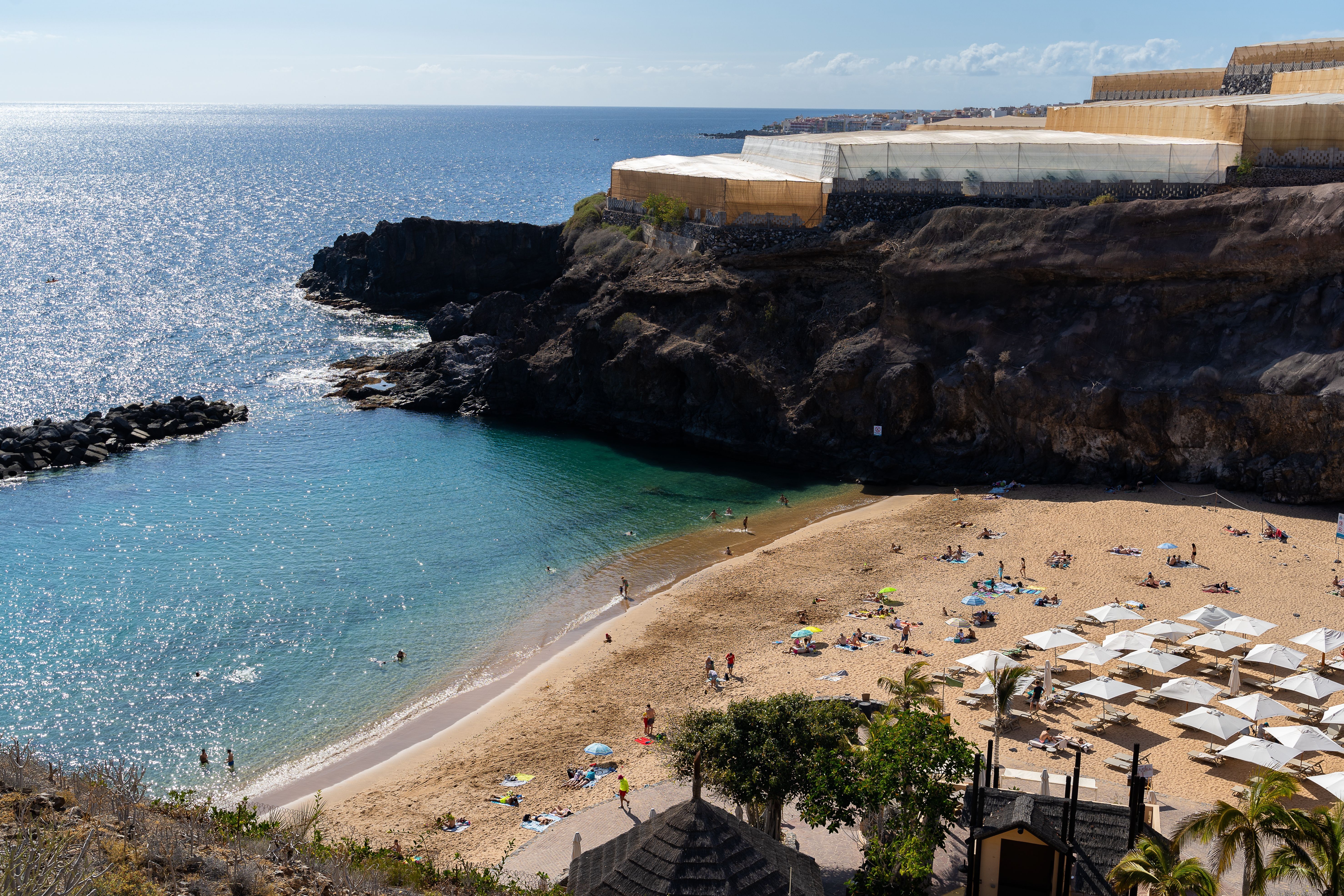 A hidden golden cove where turquoise waters meet dramatic volcanic cliffs