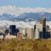 Mountains rise above the skyscrapers of the city skyline in Denver, Colorado