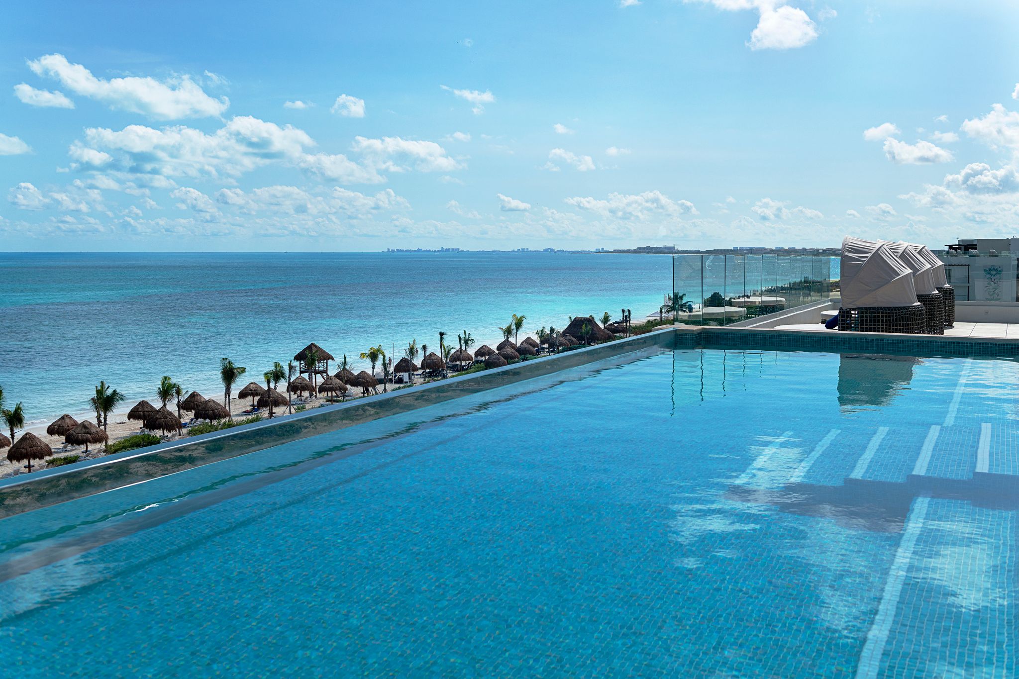Rooftop infinity pool meets endless Caribbean blue.