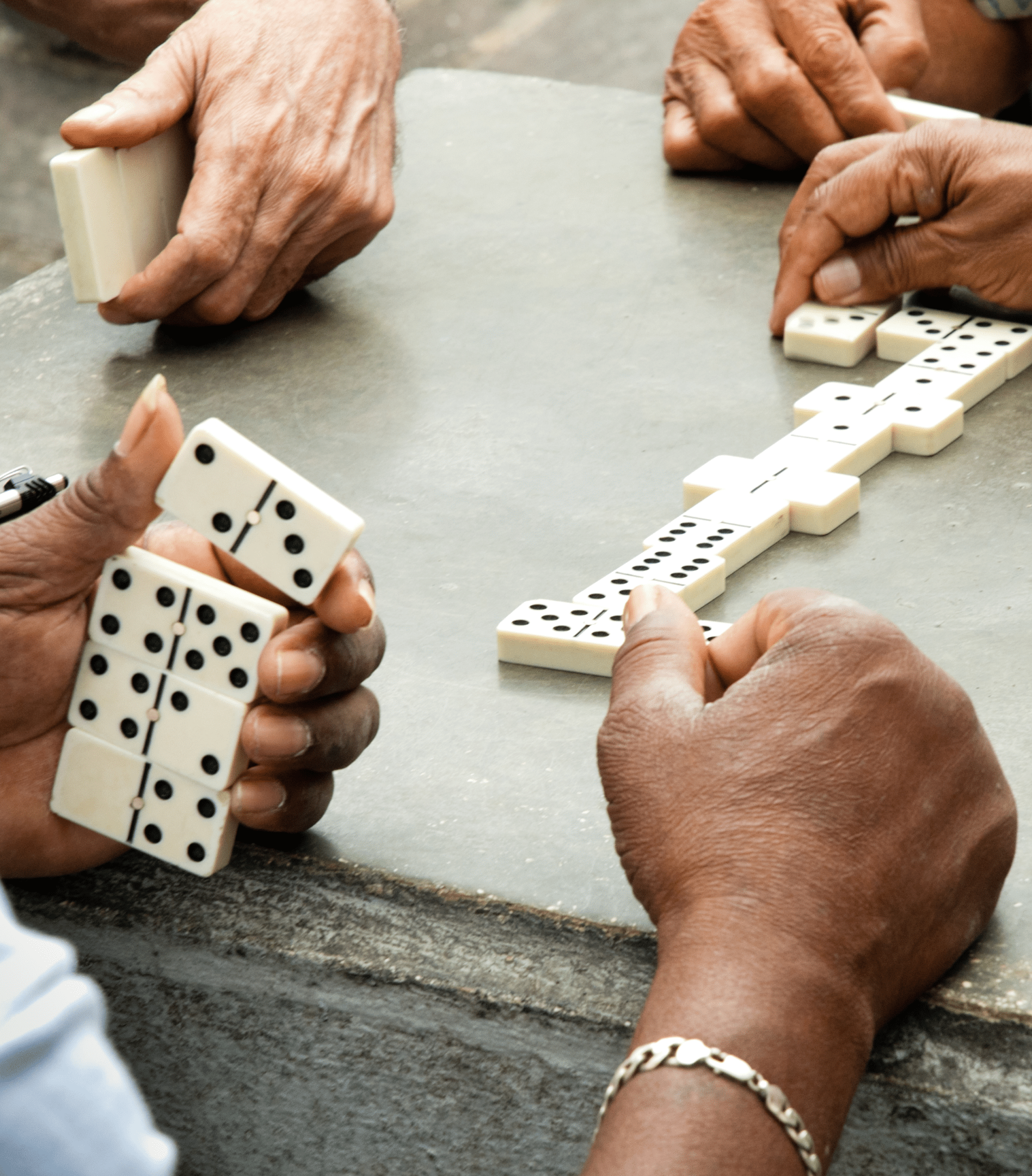 Close up of four players during a game of dominos
