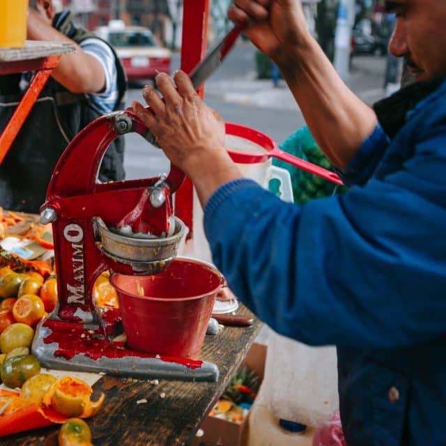 A man squeezes citrus fruits to make juice at a stall in Mexico City