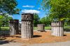 Outdoor park with portions of columns in central woodchip area.