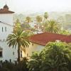 Palm trees and terracotta-roofed white buildings are seen from above in Santa Barbara, California