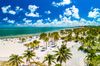 Aerial view of palm trees and white sand on Crandon Beach, Miami.