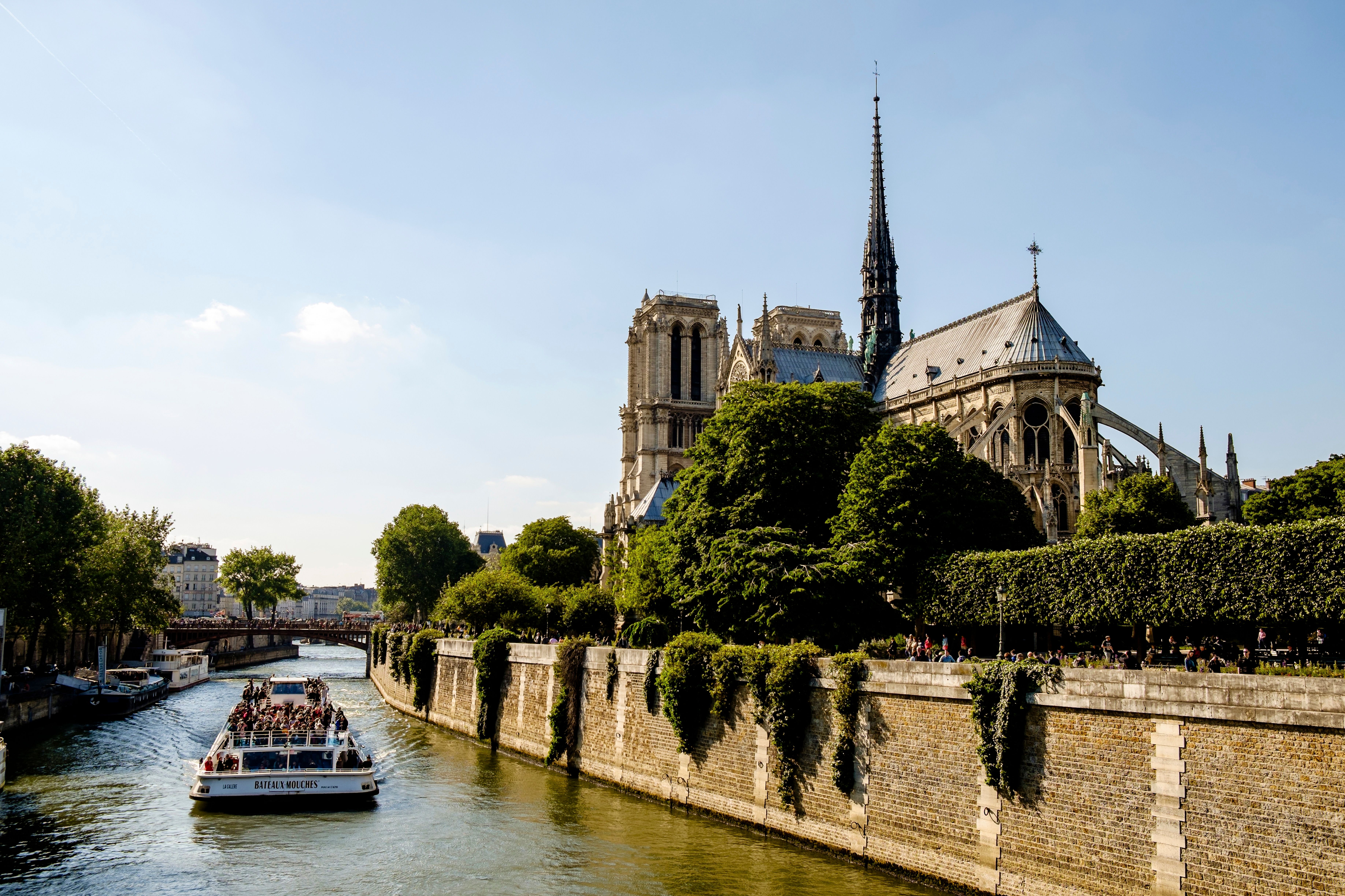 A boat cruises along the river Seine next to Notre-Dame cathedral in Paris, France