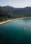 A boat anchored in the tree-lined Datai bay, Langkawi, Malaysia