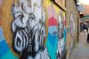 Street art murals line a brick wall near Boxpark Shoreditch in London.