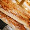 A close-up of fresh baguettes stacked on a wire rack