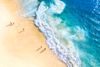 An overhead view of people on a sandy beach.