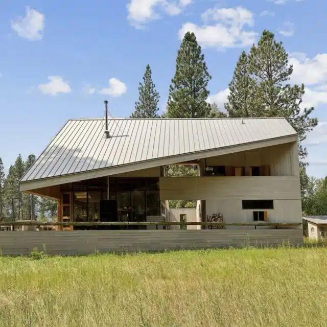 Backed by majestic mountains and trees, a strikingly designed Vrbo with angular roof in Montana